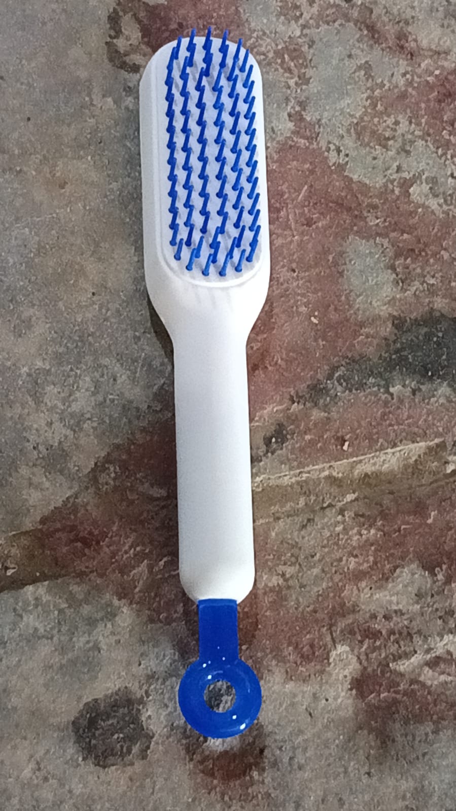 white handheld scalp brush with blue bristles scalable rotating hair styling tool for detangling and styling