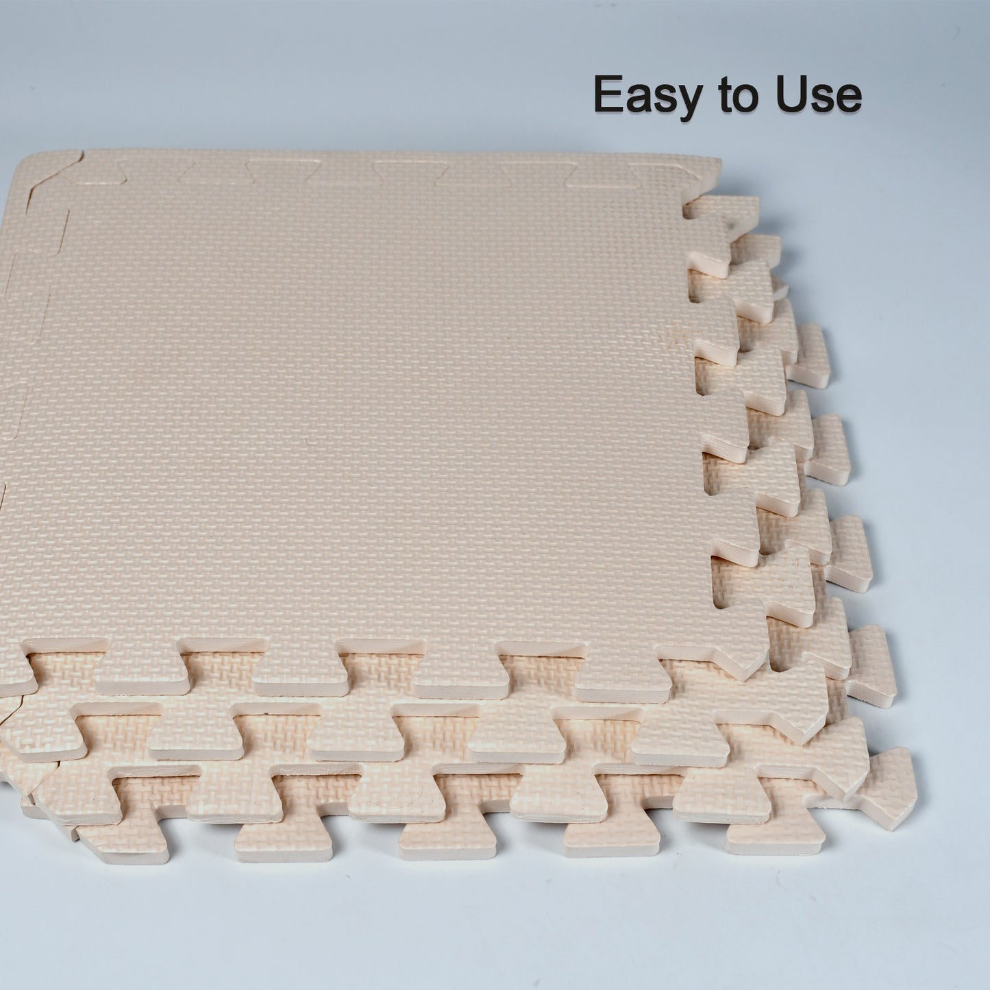 beige interlocking foam tiles stacked showing textured edges soft puzzle mats for babies crawling