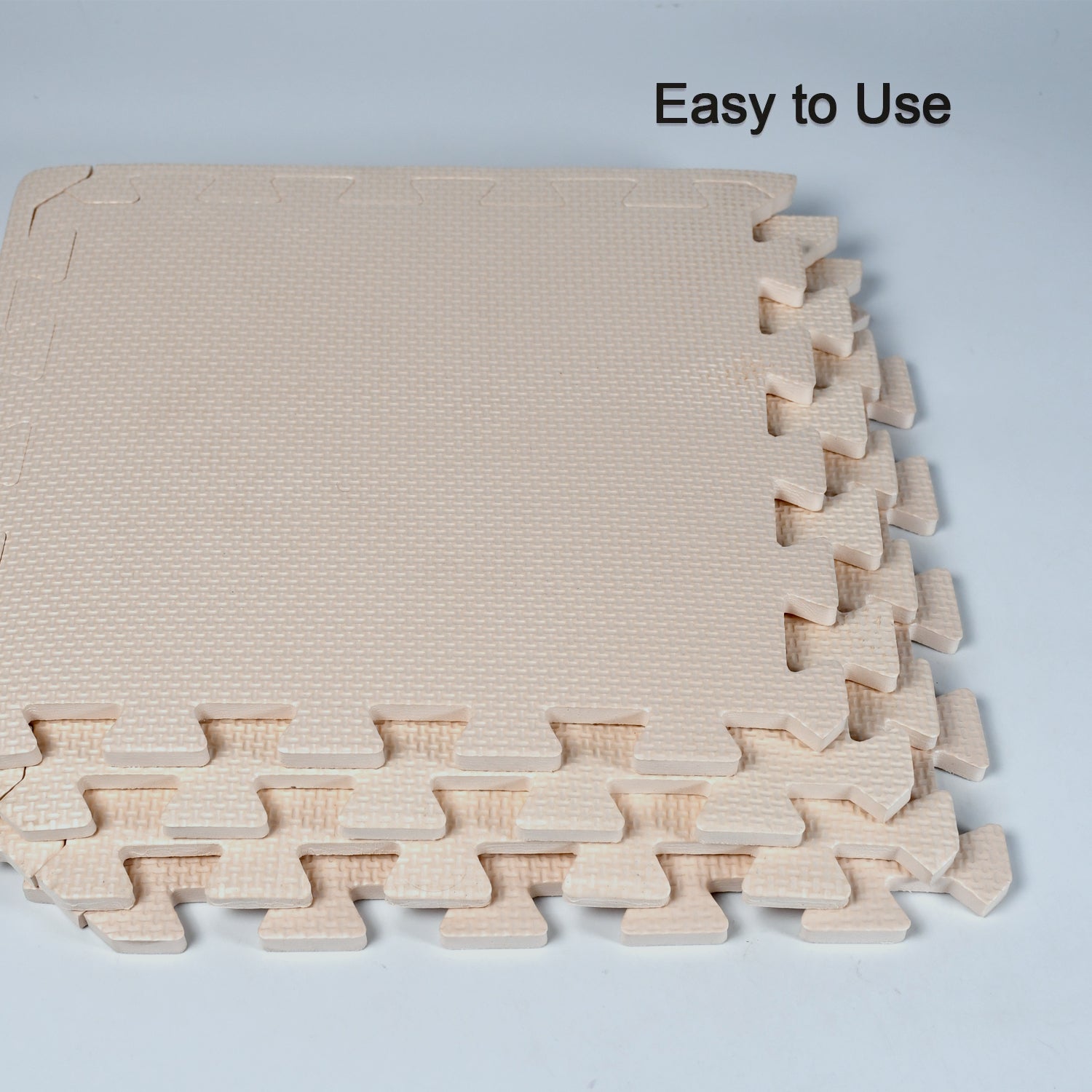 beige interlocking foam tiles stacked showing textured edges soft puzzle mats for babies crawling
