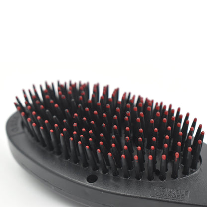 black oval hair brush with massage function featuring dense flexible bristles with red tips