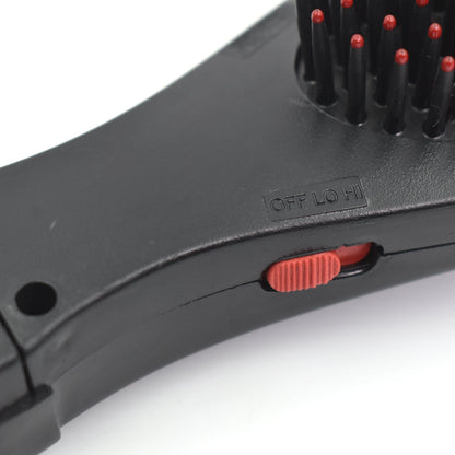 black hair brush with massage function close up showing red bristle tips and red speed switch