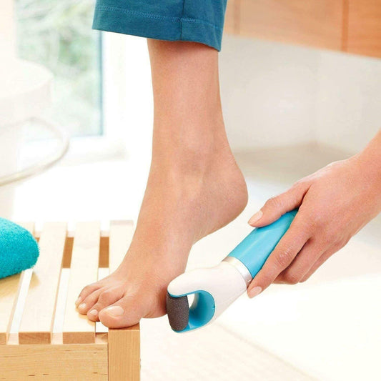 electronic dry foot file for hard skin in use, smoothing a person's foot on a wooden stool