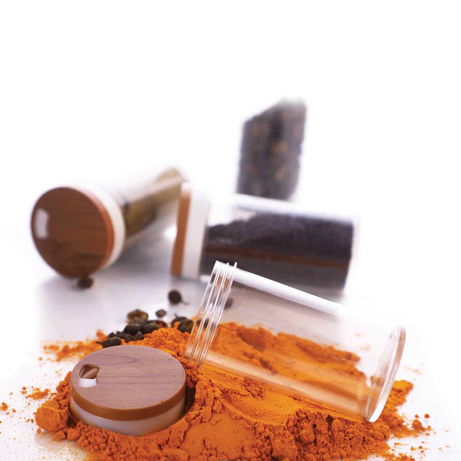 clear glass jars with wooden lids and spilled turmeric powder kitchen spice storage container