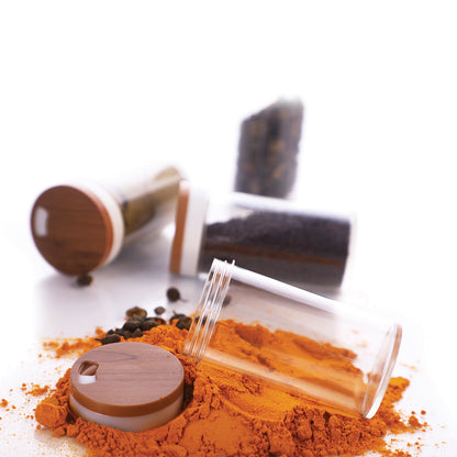 clear glass jars with wooden lids and spilled turmeric powder kitchen spice storage container
