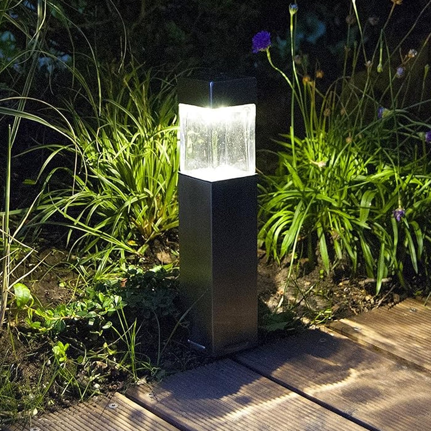 stainless steel garden bollard illuminated on wooden path at night weatherproof solar park lighting