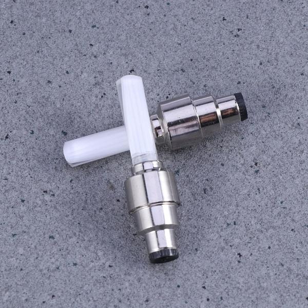 automotive metal tire valve stem caps with white plastic inserts on concrete background