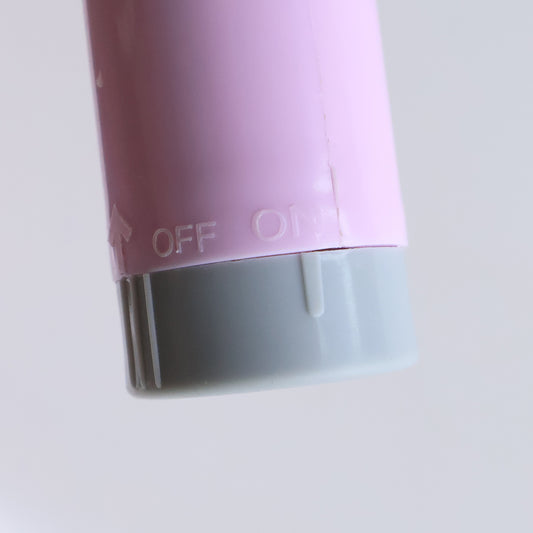 pink battery toothbrush handle close up showing off on switch and gray base best battery toothbrush for adults