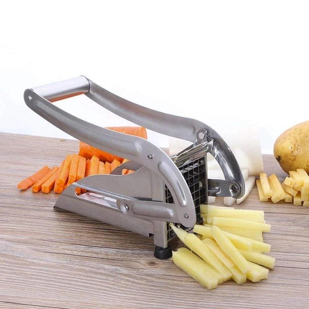 stainless steel French fry cutter machine creating uniform potato and carrot sticks on wood board