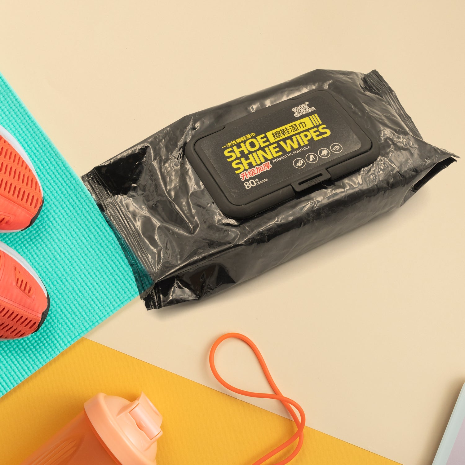 shoe cleaning wipes pack on table beside coral trainers yoga mat and water bottle for quick shoe care