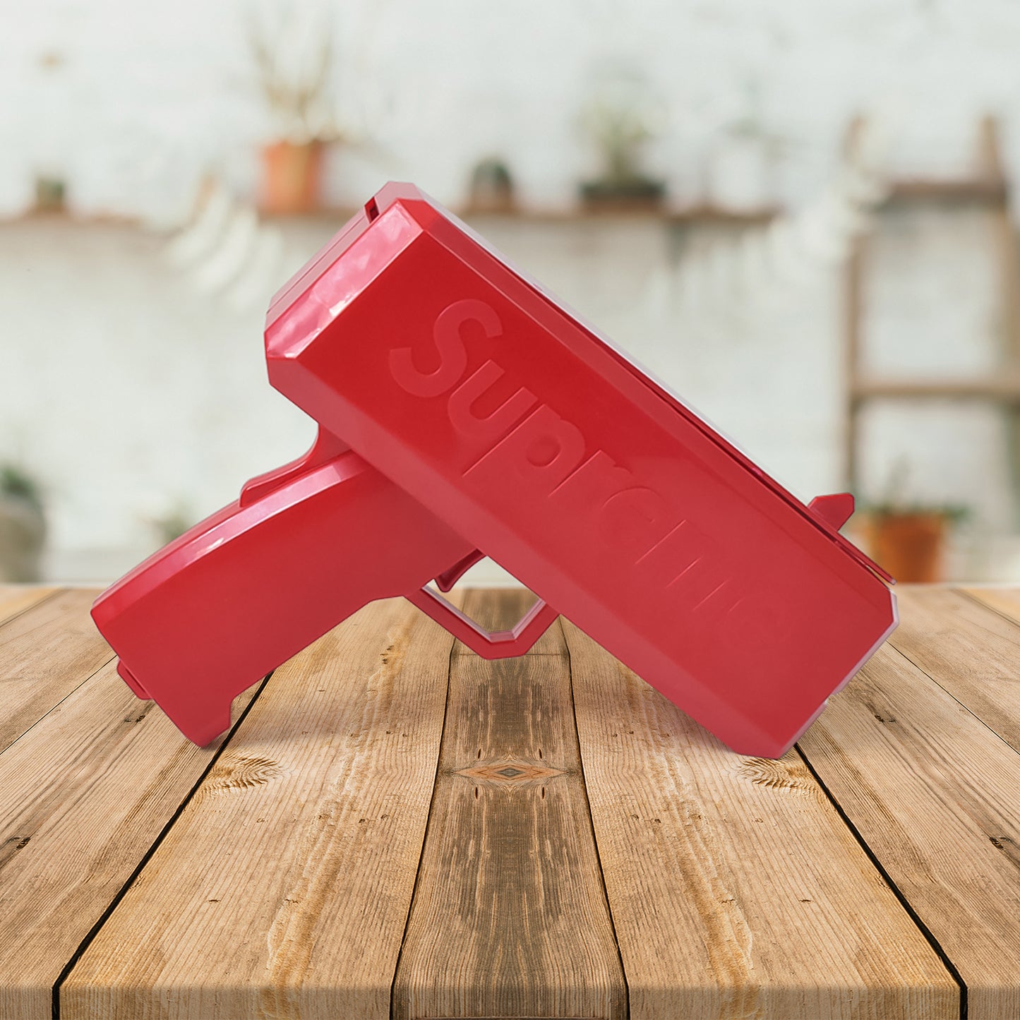 red plastic toy money gun shooter for parties on wooden table party prop shoots fake bills