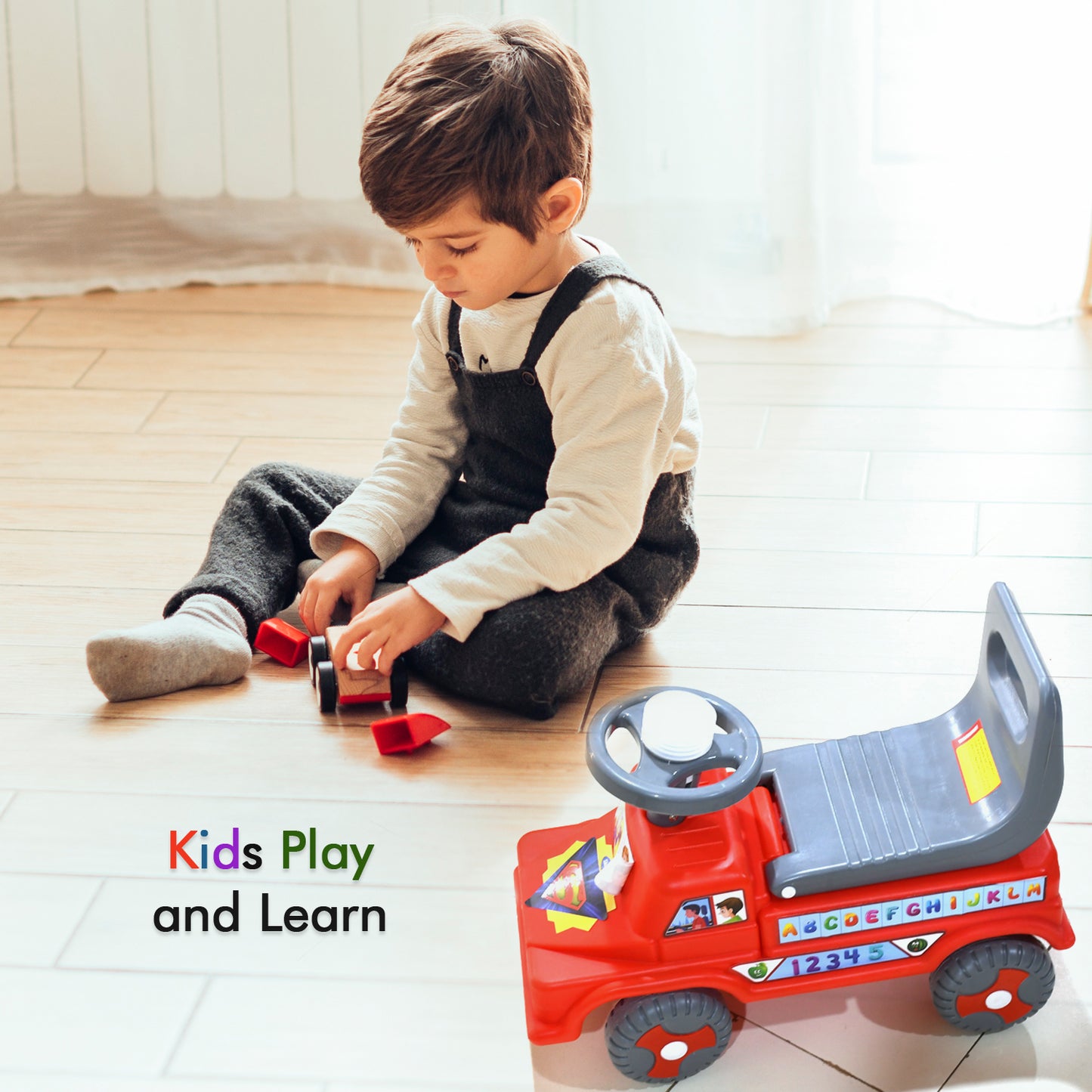 red kids ride on push car with backrest parked beside toddler playing with wooden toy car