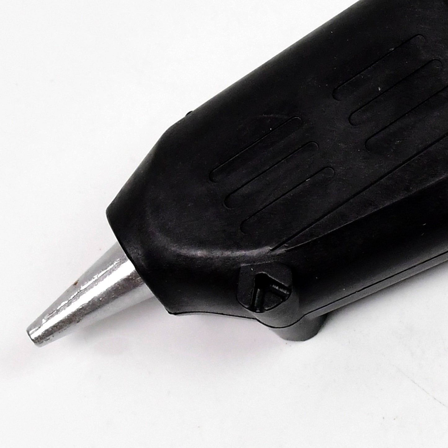 black high power glue gun for DIY projects close up of metal nozzle and textured grip on white background