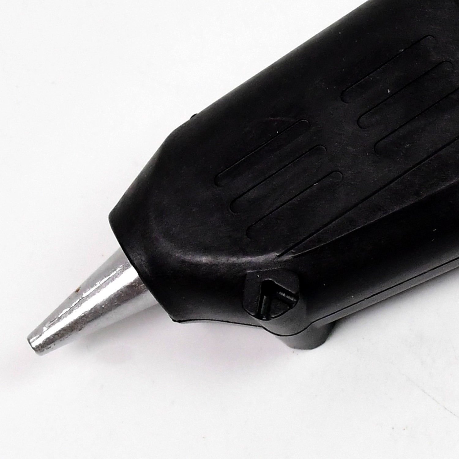 black high power glue gun for DIY projects close up of metal nozzle and textured grip on white background