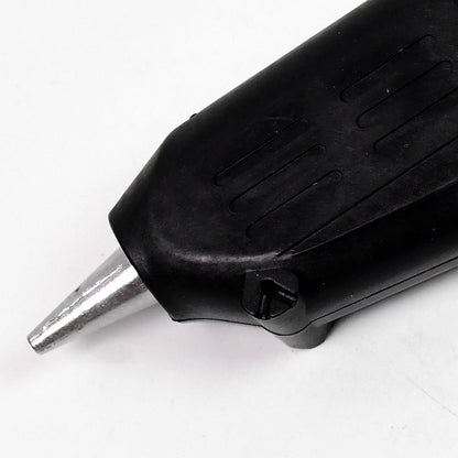 black high power glue gun for DIY projects close up of metal nozzle and textured grip on white background