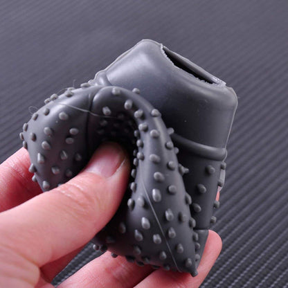 gray silicone car gear shift knob protector with textured anti slip bumps held in hand