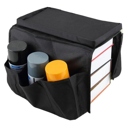 black sofa armrest organizer storage bag with top tray and side pockets holding spray cans and books