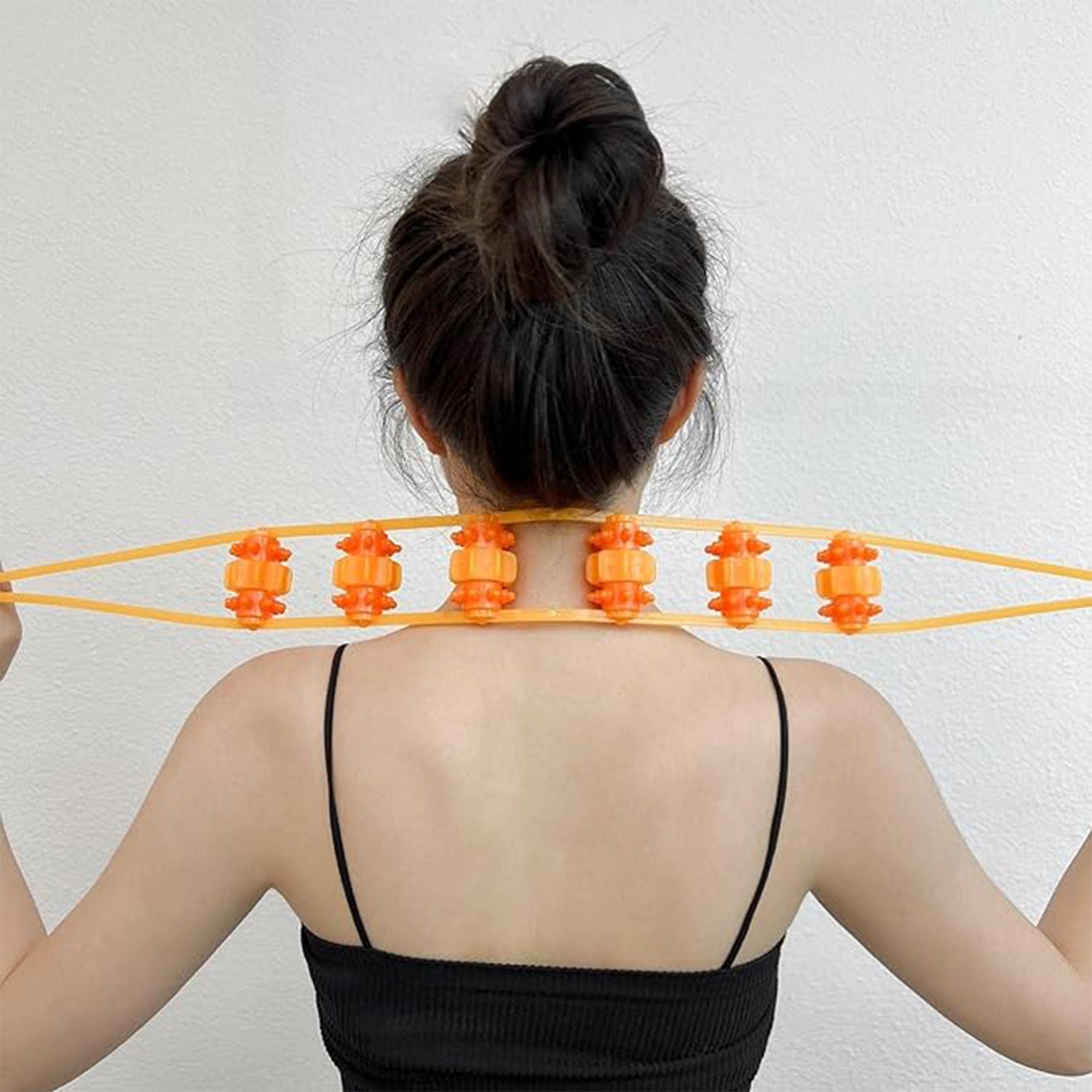 deep tissue back roller for home use held across upper back by woman with bun in black tank top