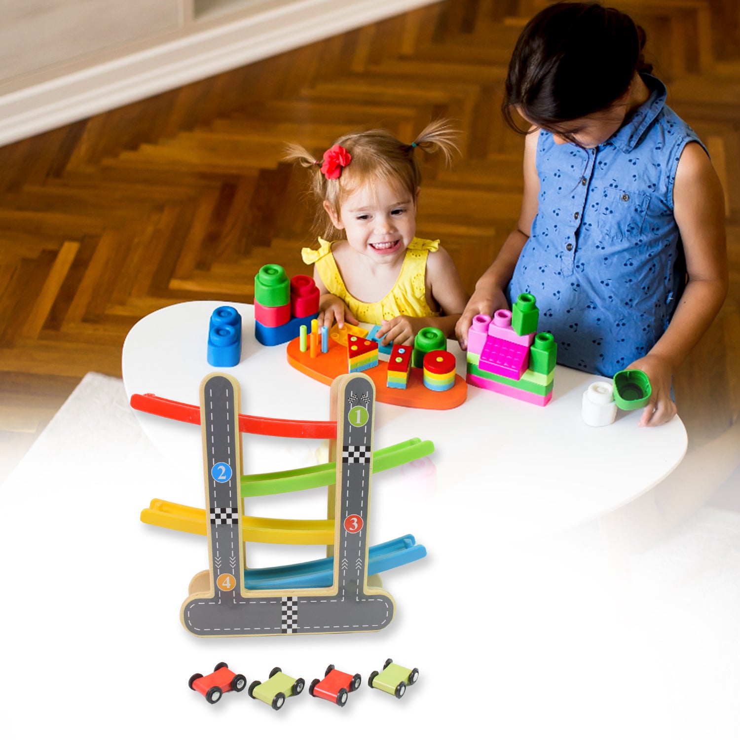 Two children playing with colorful blocks and a wooden car racer track play set with four small cars